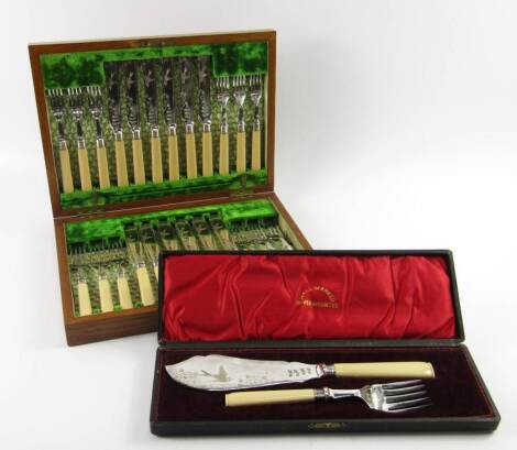 A canteen of plated fish knives and forks, early 20thC, with ivory handles, oak cased, and a pair of matching fish servers, cased.