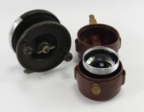 An Alcock aerial light fishing reel, 10cm diameter, and a Carl Zeiss fish eye lens, NR2358131, Pro-Tessar 1:4 f=85mm, with cased bayonet fitting (2).