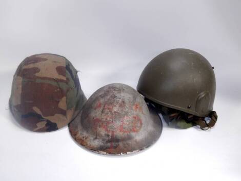 A Cogebi No 1 helmet, circa 1971, with camouflage fabric, a tin helmet and a galvanised helmet, (3).