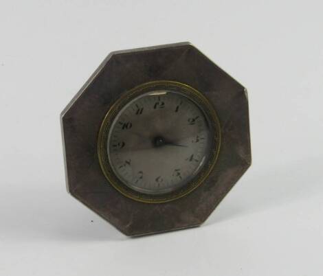 An Art Deco white metal cased octagonal strut clock, with engine turned sunburst decoration, silvered dial bearing Arabic numerals, 8cm diameter.