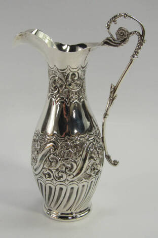 A Victorian silver jug, of semi fluted baluster form decorated with embossed bands of scrolling leaves and flowers, Maurice Freeman, London 1899, 4.235t oz.