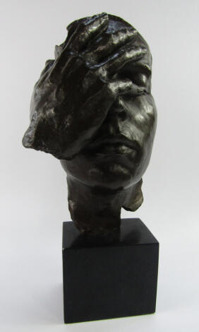 A bronze sculptured bust, cast with a hand clasped to its face, raised on a black marble base, 42cm high.