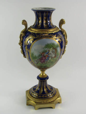 A Sevres style porcelain and ormolu mounted vase, 20thC, of twin handled baluster form reserve painted by C Hiccolier with an amorous couple in a garden, verso a garden, against a bleu du roi and gilt foliate ground, 44cm high.