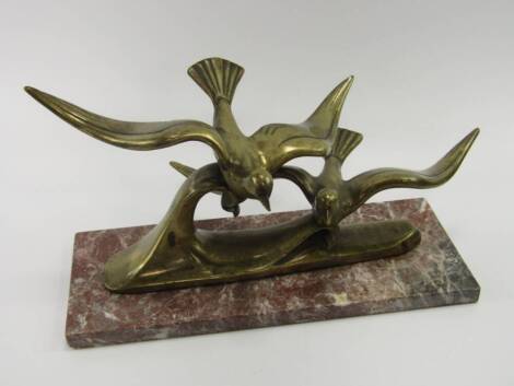 An Art Deco style brass sculpture of two birds in flight, raised on a rectangular marble base, 40cm x 16.5cm x 20cm.