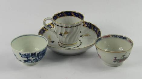 A Worcester First Period blue and white tea bowl, decorated with a fence and garden pattern, further tea bowl and a Barr Worcester fluted coffee cup and saucer decorated in gilt and cobalt blue with floral sprigs, (AF).