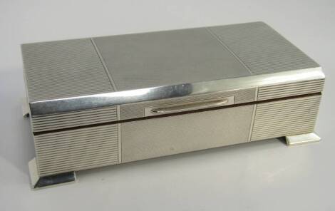 A silver Art Deco twin division cigarette box, with engine turned decoration, raised on bracket feet, Walker & Hall, Birmingham 1957, 18cm x 9.5cm x 5.5cm.