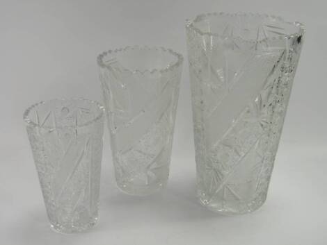 A set of three Bohemian graduated cut glass vases, of tapering, bucket form with star, strawberry and prismatic cut decoration, 20.5cm, 25.5cm and 33cm high.