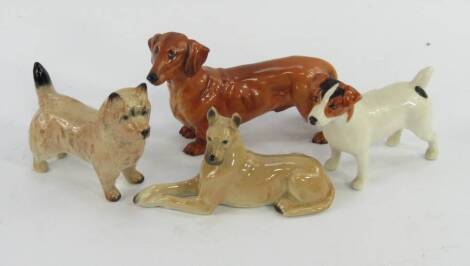 A Royal Doulton figure of a dachshund HN1141, together with a Beswick figure of a Jack Russell, another of a Cairn Terrier and a Goebbel figure of a Boxer dog, (4).