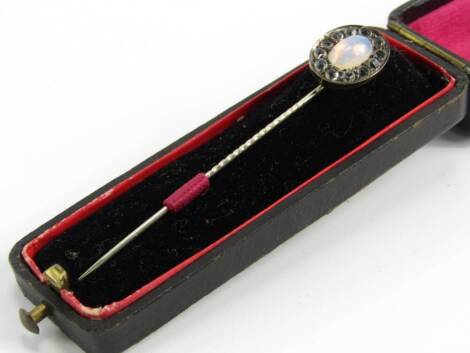 A Victorian white metal moonstone and paste set tie pin, boxed.