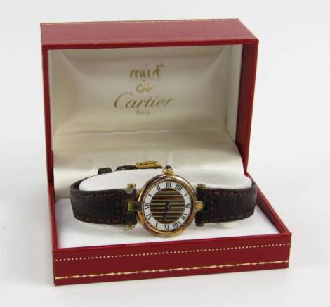 A Cartier lady's Vermeil Quartz wristwatch, round silver gilt case, striped dial with silvered chapter ring bearing Roman numerals, Must de Cartier, Swiss movement 042113590004, with leather strap, cased.