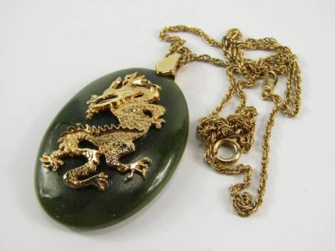 A dragon necklace, with oval pendant and gold plated chain.