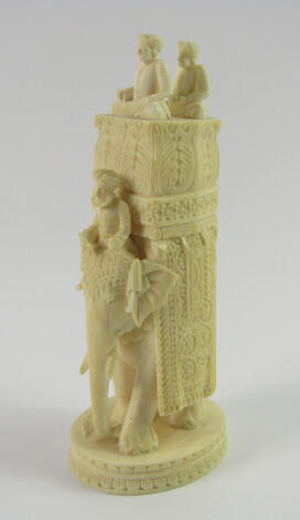 An Indian ivory carving of an elephant, early 20thC, with a rider and howdah containing two princes, raised on an oval lotus flower base, 14cm high.