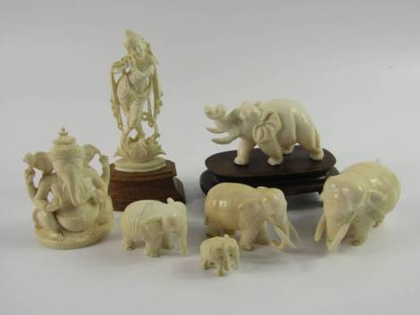 An Indian ivory carved herd of elephants, largest 8cm long, a further elephant raised on a wooden stand, a carving of Shriva, 7.5cm high, and another of a Hindu Goddess, (7).