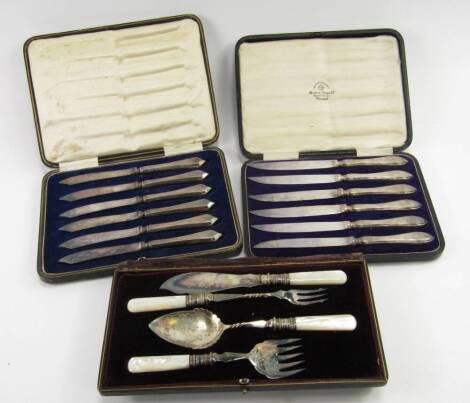 A set of six George V silver fruit knives, Sheffield 1921, 4.68t oz, further set of knives, Sheffield 1917, 5.03t oz, and a set of four plated serving implements with mother of pearl handles, all cased.