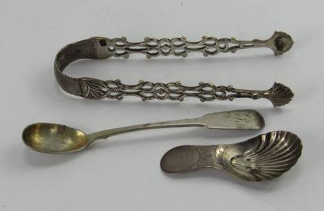 A George III silver scallop shell caddy spoon, with bright cut engraving, a pair of sugar tongs and a mustard spoon, 1.45t oz.