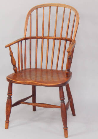 A 19thC oak and elm Windsor chair, raised on turned legs united by an H frame stretcher.