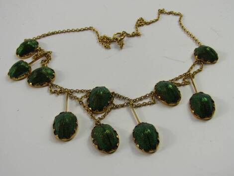 A yellow metal and scarab beetle necklace, with two beetles on a belcher chain, 9.8g total weight.