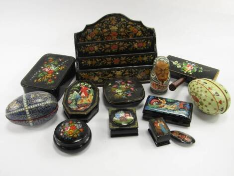 Russian painted black lacquer and metal boxes, together with a letter rack, brooch and an enamel brush, together with two tin replicas of Faberge eggs and a set of Russian political dolls, (13).