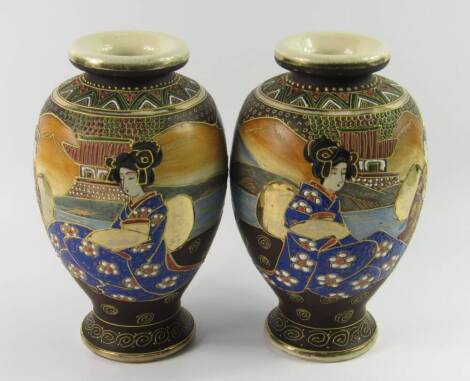 A pair of Satsuma earthenware vases, of baluster form painted with Geisha Girls in a landscape, 25cm high.