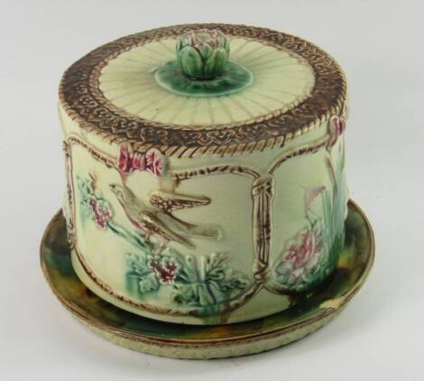 A majolica cheese dish and cover, late 19thC, the cover moulded with panels of birds and water lilies, 22cm x 17cm, (AF).