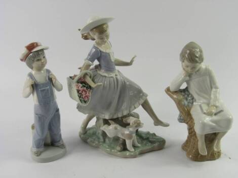 A Lladro porcelain figure of a girl, with a basket of lilies and a puppy at her feet, raised on a naturalistic base, 26cm high, (AF), together with a boy in a night gown sitting in a tree, and a boy in dungarees with an accordian, (3).