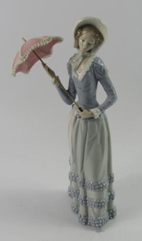 A Lladro porcelain figure of a lady, with an open parasol, 32cm high.