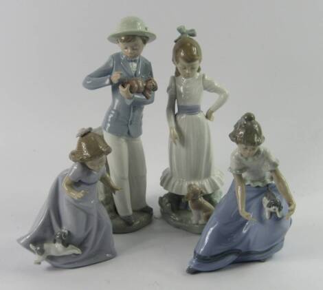 A Lladro Nao porcelain figure of a boy, holding a puppy, and three figures of girls with puppies, (4).