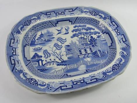 A blue and white pottery meat platter, decorated in the Willow pattern, early 19thC, printed Semi-China mark, 42cm x 53.5cm.