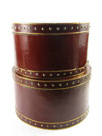 A graduated pair of faux leather brass bound and metal studded hat boxes, 38.5cm x 22.5cm and 35cm x 20.5cm.