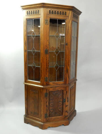 A reproduction linen fold oak display cabinet, with leaded glazed doors 100cm wide