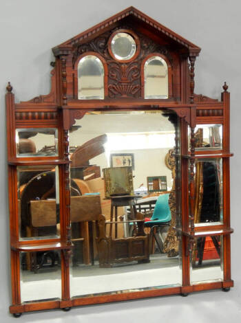 A Victorian walnut overmantel mirror of architectural form, with bevel plates and an arrangement of shelves, 116cm wide x 142cm high