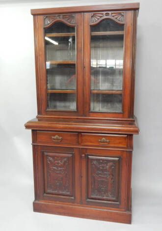 A late Victorian carved walnut cabinet bookcase, 110cm wide