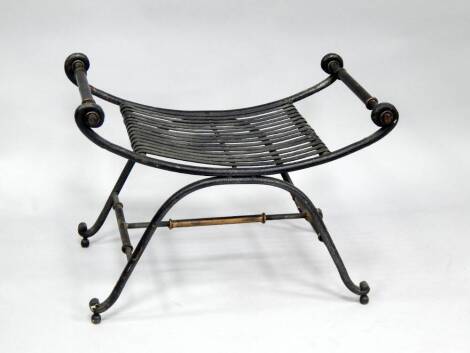 A wrought iron window seat, of x-frame form