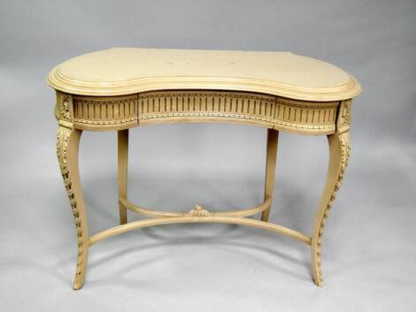 A Louis XVI style kidney shape dressing table, painted in cream, 106cm wide