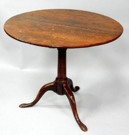 A George III oak supper table, with circular tilt top on a revised bird cage mechanism, turned pillar and three outsplay legs, 83cm dia.