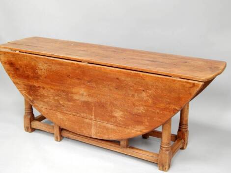 A 19thC pitch pine wake table, with turned legs and moulded square framing, 180cm long