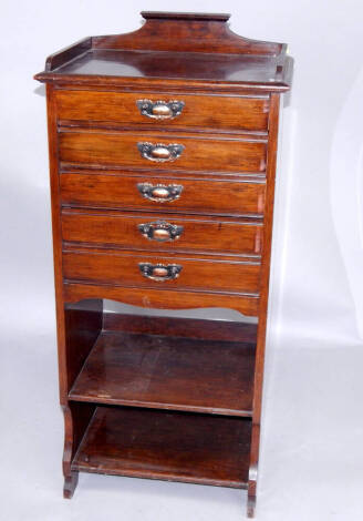 An Edwardian oak music cabinet, of five drawers with shelves below, 110cm x 50cm x 35cm.