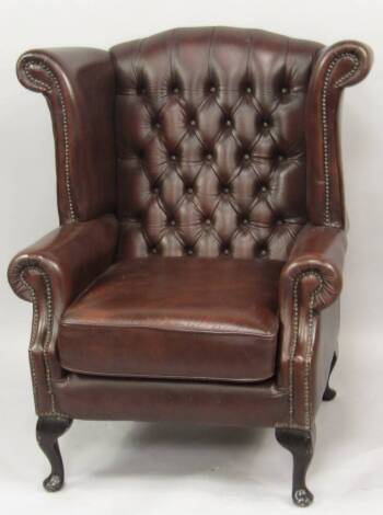 A brown leather wingback armchair.