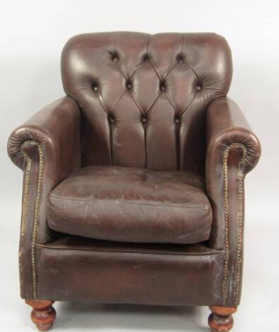 A brown leather upholstered club armchair.