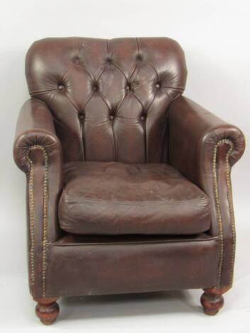 A brown leather upholstered club armchair.