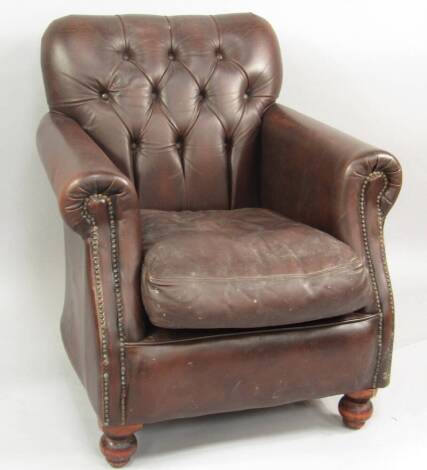 A brown leather upholstered club armchair.