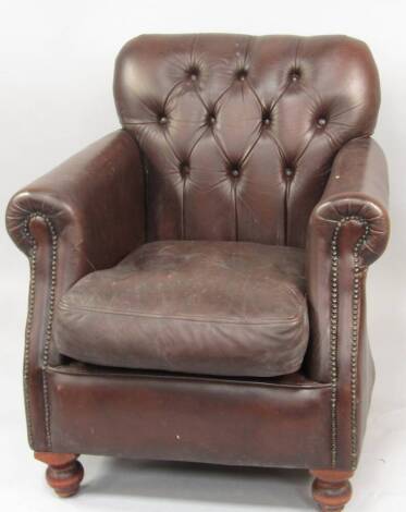 A brown leather upholstered club armchair.