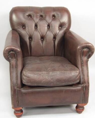 A brown leather upholstered club armchair.