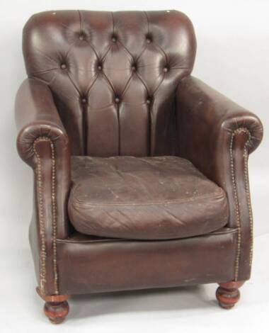 A brown leather upholstered club armchair.