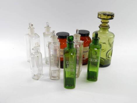 Chemists clear and green glass bottles, each marked to the side with the contents description, two brown acid jars and a green glass decanter, all empty, (29).