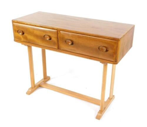 An Ercol blonde elm and beech side table, with two frieze drawers, raised on two pairs of chamfered supports, on an H frame base, 80cm high, 107cm wide, 45cm deep.