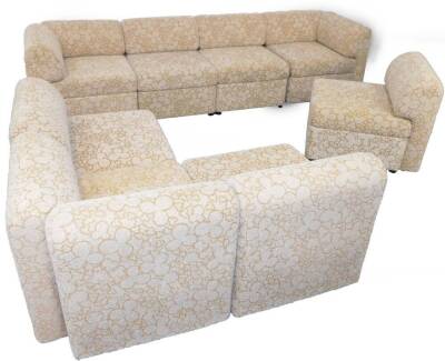 A 1970's vintage block sofa suite, of eight sections, upholstered in gold and cream floral fabric.