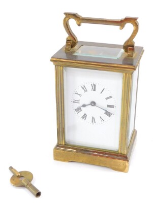 A brass early 20thC carriage clock, enamel dial bearing Roman numerals, the case of conventional form, with key, 12cm high, 8cm wide, 6cm deep.