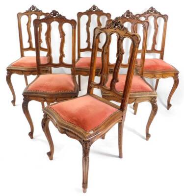 A set of six Continental late 19thC oak single dining chairs, with foliate carved crest rails, studded red fabric seats, raised on leaf carved slender cabriole legs.