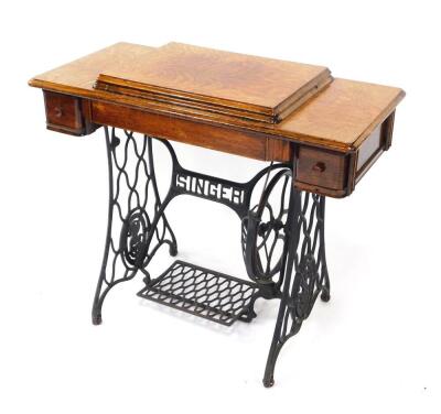 A Singer oak cased sewing table, containing an Egyptian model sewing machine, raised on a cast iron treadle base, 78cm high, 90cm wide, 43cm deep.